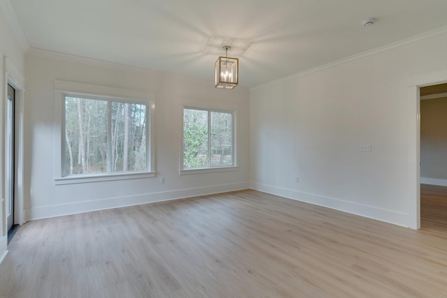 empty room featuring crown molding, an inviting chandelier, and light hardwood / wood-style floors