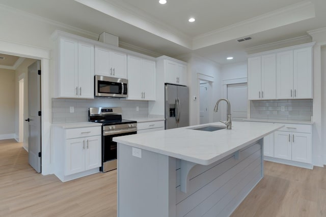 kitchen featuring white cabinets, an island with sink, appliances with stainless steel finishes, and sink