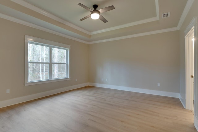 unfurnished room with ceiling fan, a raised ceiling, light hardwood / wood-style flooring, and crown molding