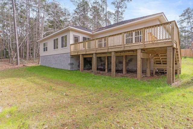 back of property featuring a wooden deck and a yard