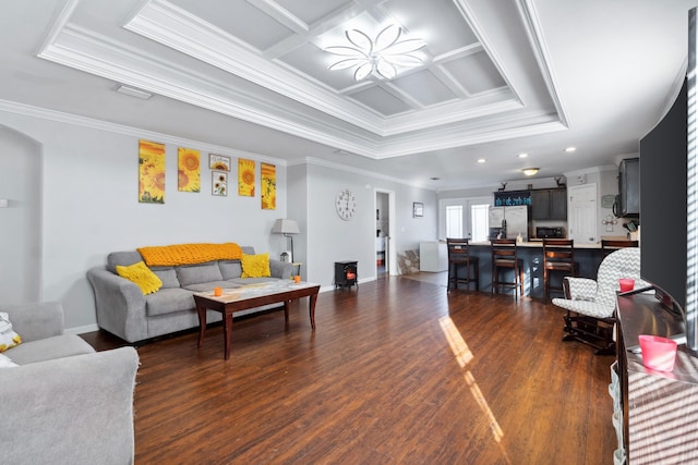 living room with a raised ceiling, dark wood-type flooring, coffered ceiling, and ornamental molding