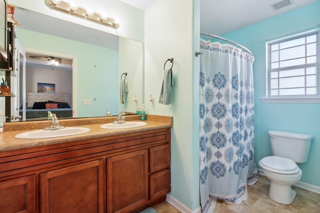 bathroom featuring curtained shower, vanity, and toilet