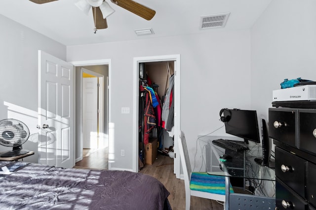 bedroom featuring hardwood / wood-style floors, ceiling fan, a spacious closet, and a closet