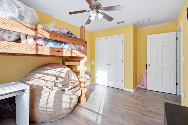 bedroom with hardwood / wood-style floors, ceiling fan, and a closet