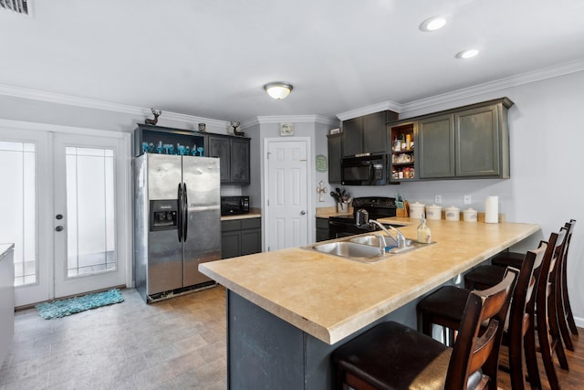 kitchen with kitchen peninsula, a kitchen breakfast bar, crown molding, sink, and black appliances