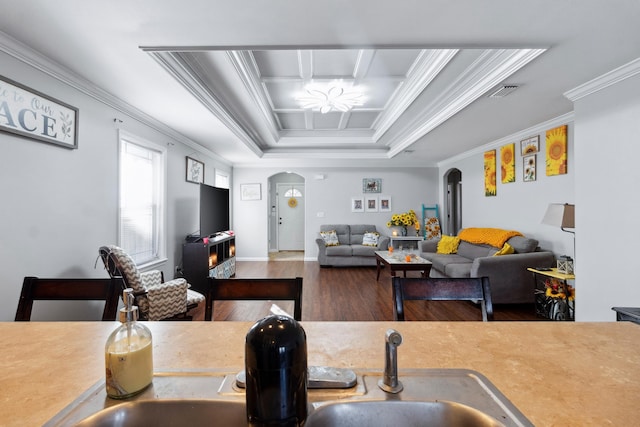 interior space with hardwood / wood-style floors, sink, crown molding, a fireplace, and a tray ceiling