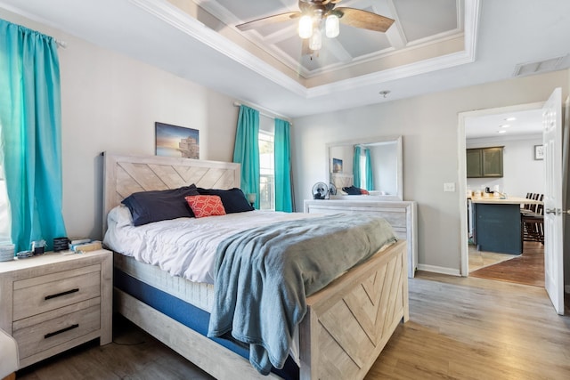 bedroom with ceiling fan, crown molding, coffered ceiling, and light wood-type flooring