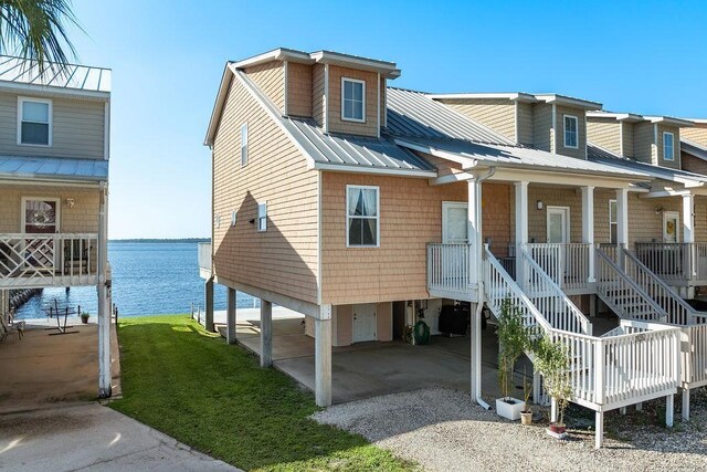 view of front of property with a carport, a water view, and a front yard