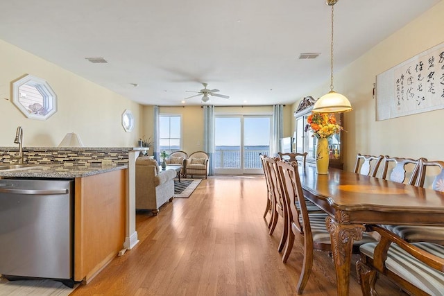 dining area featuring ceiling fan, light wood-type flooring, and sink