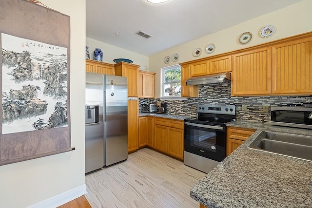 kitchen with sink, stainless steel appliances, tasteful backsplash, exhaust hood, and light wood-type flooring