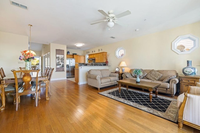 living room with light hardwood / wood-style floors and ceiling fan