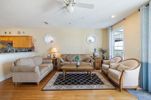 living room featuring wood-type flooring and ceiling fan