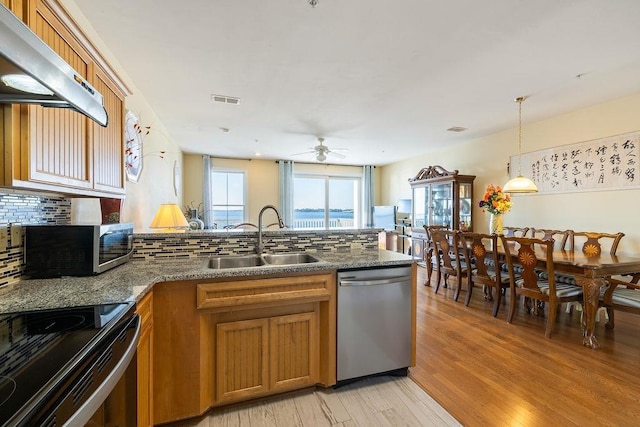 kitchen with ceiling fan, dishwasher, sink, range hood, and light hardwood / wood-style floors