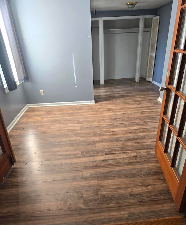 unfurnished bedroom with a closet and dark hardwood / wood-style flooring