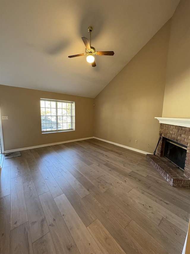 unfurnished living room with ceiling fan, wood-type flooring, lofted ceiling, and a fireplace