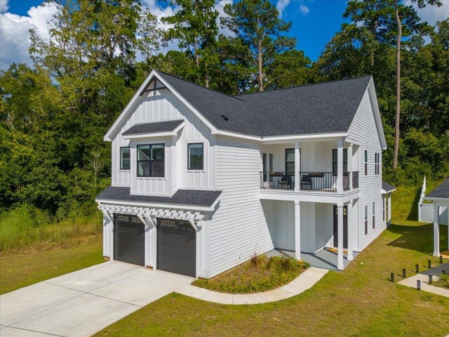 view of front of property with a front lawn, a garage, and a balcony