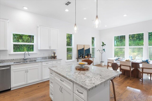 kitchen with white cabinets, sink, light wood-type flooring, and dishwasher