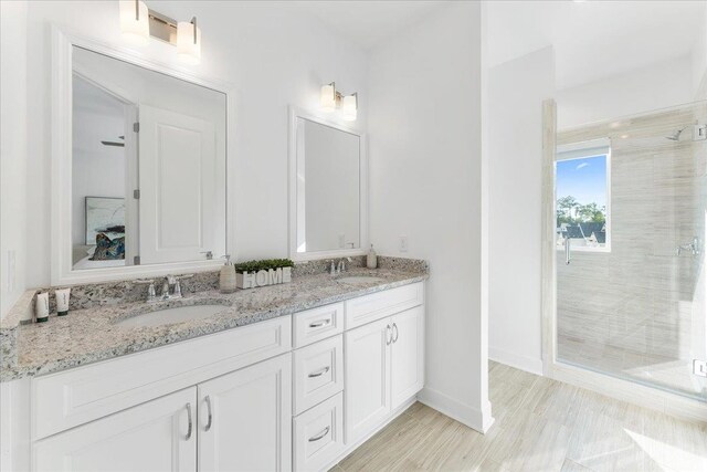 bathroom with an enclosed shower, vanity, and hardwood / wood-style flooring