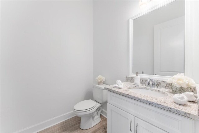 bathroom with vanity, hardwood / wood-style flooring, and toilet