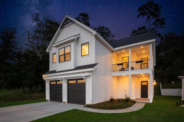 modern farmhouse with a garage, a lawn, and a balcony