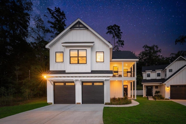 modern farmhouse style home featuring a garage, a lawn, and a balcony