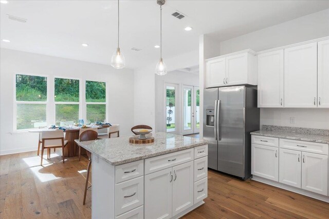 kitchen featuring white cabinetry, stainless steel refrigerator with ice dispenser, hardwood / wood-style flooring, and plenty of natural light