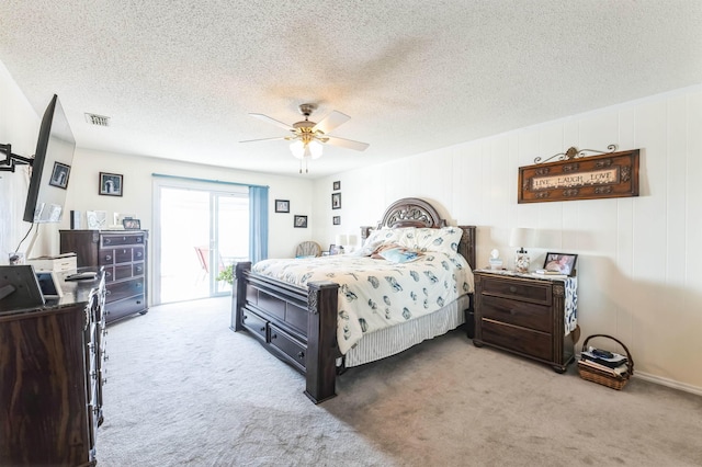 bedroom featuring ceiling fan, access to outside, a textured ceiling, and carpet floors