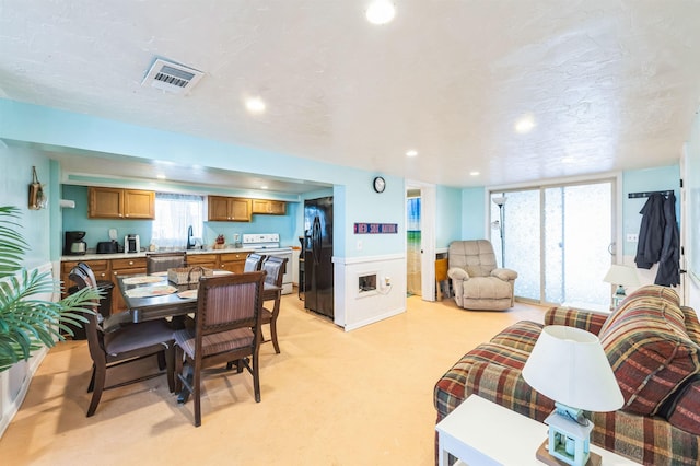 carpeted dining space featuring sink and a textured ceiling