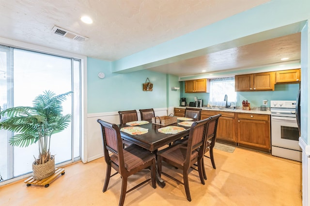 dining space featuring sink and a textured ceiling