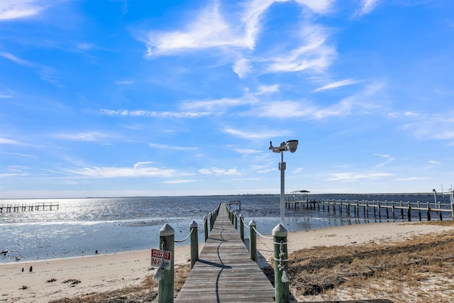 dock area with a water view and a beach view