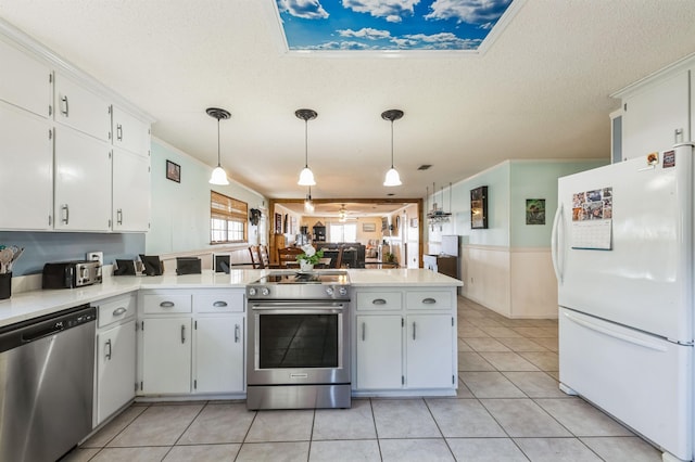 kitchen with white cabinets, pendant lighting, and stainless steel appliances