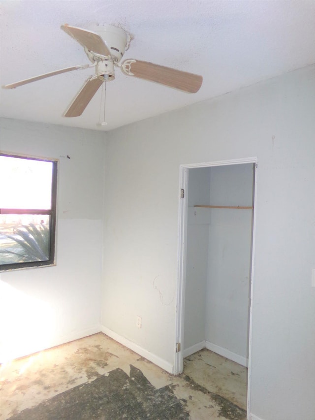 unfurnished bedroom featuring ceiling fan and a closet