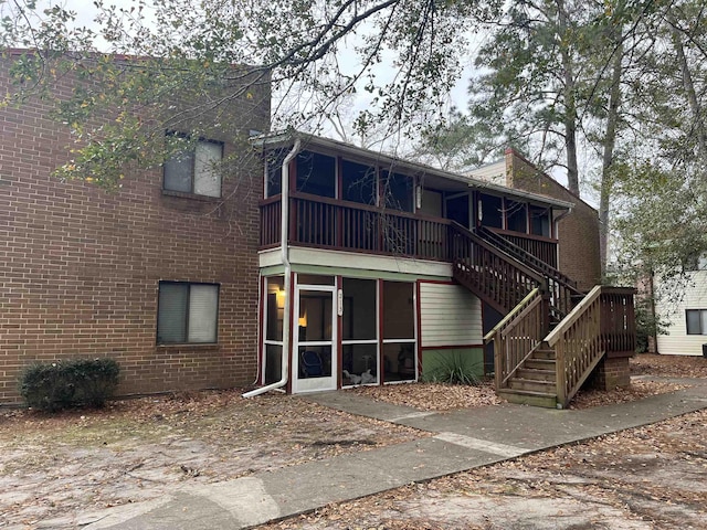 rear view of house featuring a sunroom