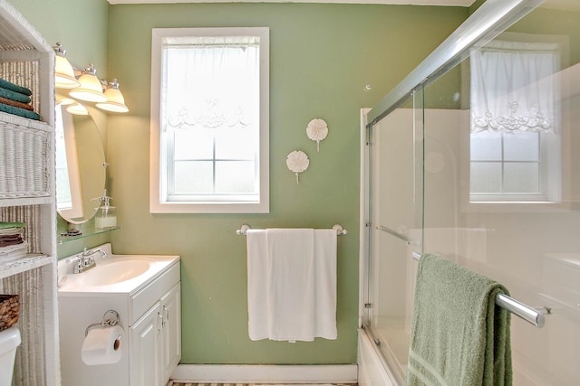 bathroom with bath / shower combo with glass door and vanity