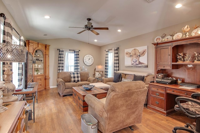 living room featuring ceiling fan, light wood-type flooring, and vaulted ceiling