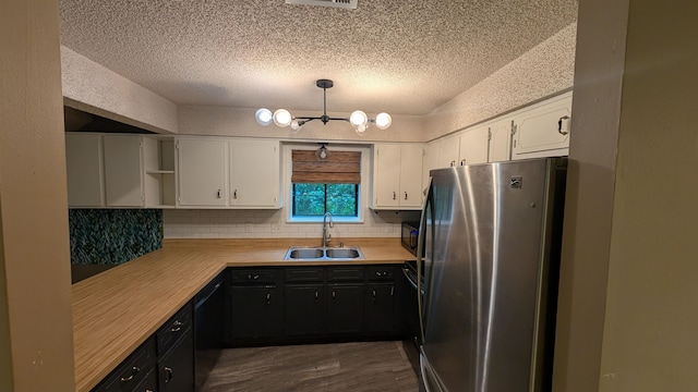 kitchen featuring stainless steel fridge, tasteful backsplash, a textured ceiling, sink, and white cabinets