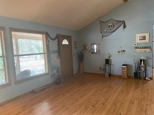 entrance foyer with vaulted ceiling and light hardwood / wood-style flooring