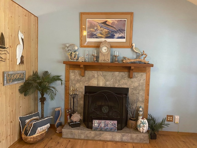 room details featuring wooden walls, hardwood / wood-style flooring, and a fireplace