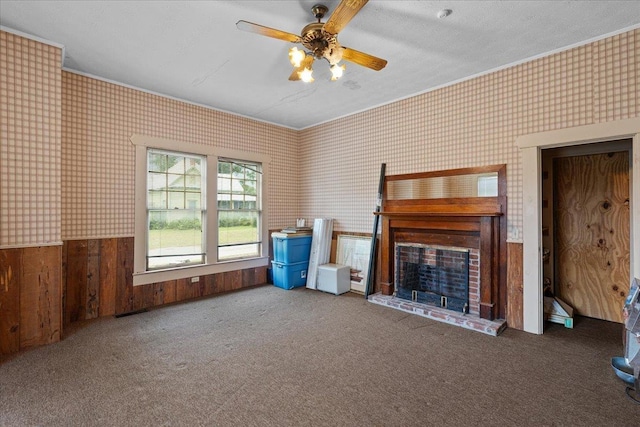 315 W Green St, Perry, FL 32347 - unfurnished living room with ornamental molding, a fireplace with raised hearth, wallpapered walls, ceiling fan, and carpet