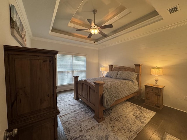 bedroom featuring dark hardwood / wood-style flooring, ornamental molding, a raised ceiling, and ceiling fan