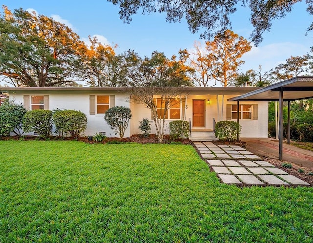 single story home featuring a front lawn and a carport