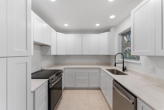 kitchen with white cabinetry, sink, stainless steel dishwasher, and electric range