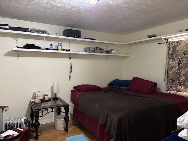 bedroom with hardwood / wood-style flooring and a textured ceiling