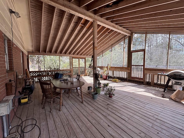 sunroom featuring vaulted ceiling with beams