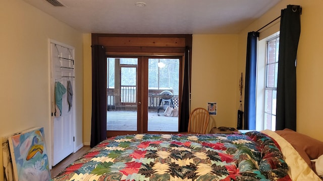 bedroom featuring access to exterior, hardwood / wood-style floors, and french doors