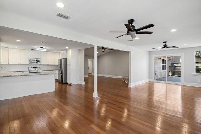 unfurnished living room featuring baseboards, visible vents, dark wood finished floors, and recessed lighting