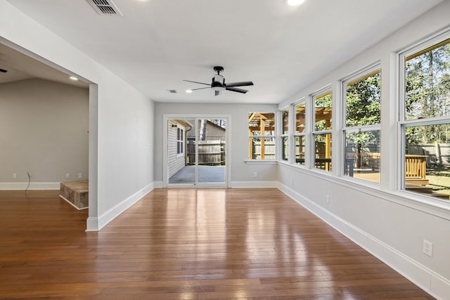 unfurnished sunroom with a ceiling fan, a wealth of natural light, and visible vents