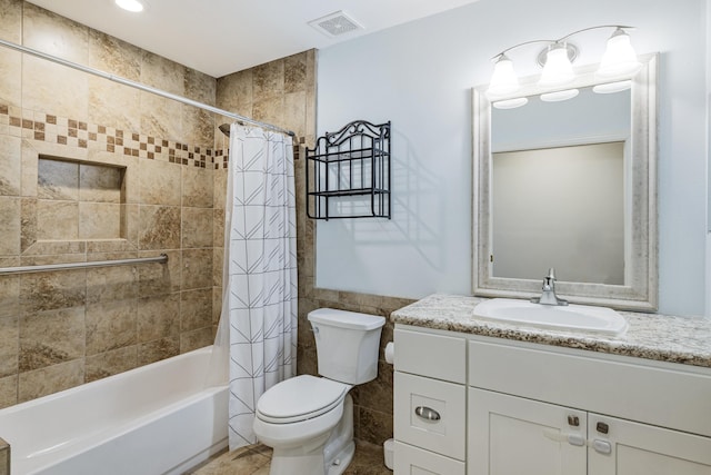 full bath with visible vents, toilet, shower / tub combo with curtain, vanity, and tile walls