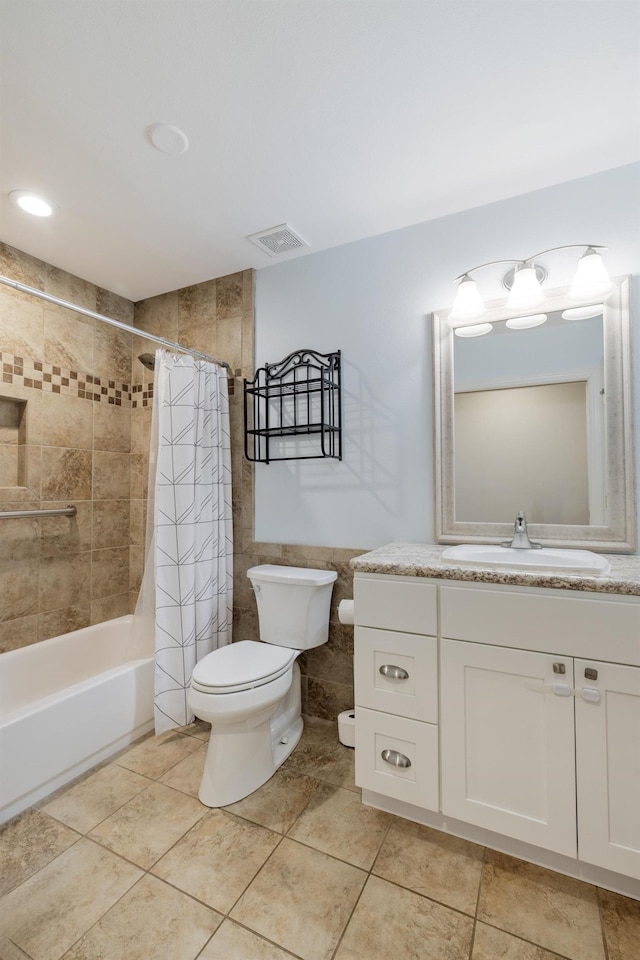 full bath featuring shower / tub combo with curtain, tile walls, visible vents, toilet, and vanity