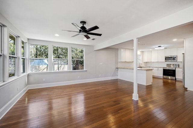 unfurnished living room featuring dark wood-style floors and baseboards